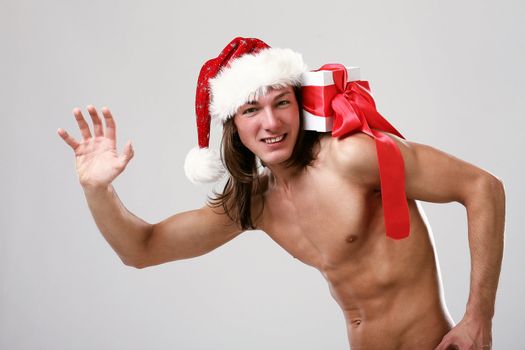 Young sexy man with gift in christmas hat isolated on white background