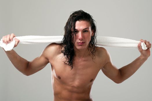 Young sexy man with long hair and towel isolated on white background