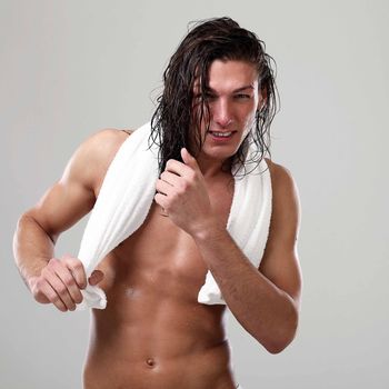 Young sexy man with long hair and towel isolated on white background