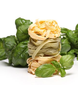 Fresh and tasty tagliatelli with spinach leaves isolated over white background