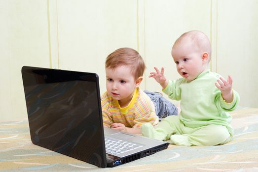 Little girl and boy using laptops.viewing the baby film