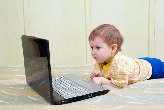 Small baby with laptop .Baby with surprised express working on laptop