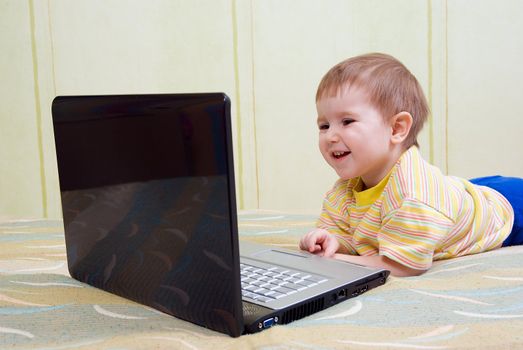 Small baby with laptop .Baby with surprised express working on laptop