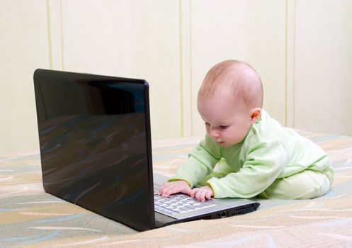 Small children in diapers playing with a laptop computer