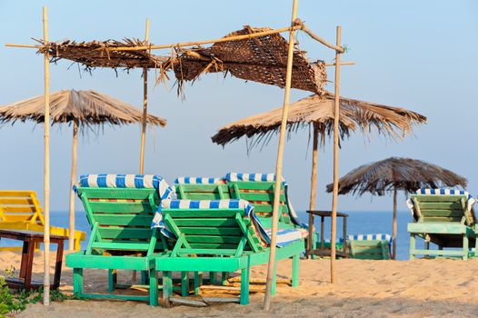 Exotic lean-tos of palm leaves on tropical beach