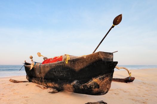 Old fishing boat on the sandy beach in Goa