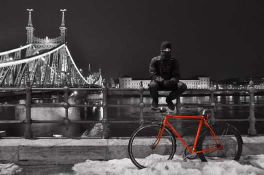 Cyclist sitting next to his red bike at Budapest