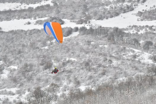Paraglider flying in winter environment