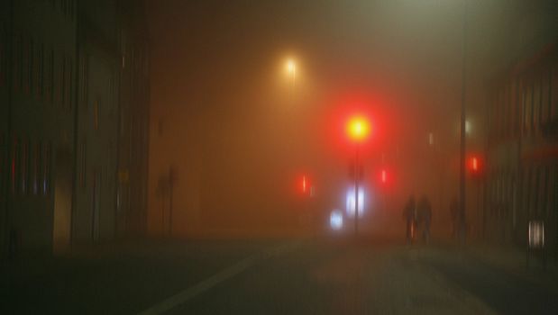 Cyclists in the foggy night - Denmark. Blurred capture - filmgrain added to improve the atmosphere.