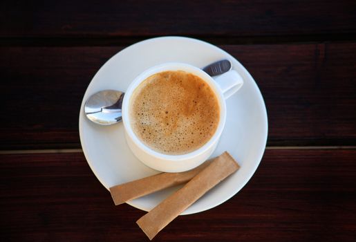 White porcelain cup of freshly brewed coffee with sugar