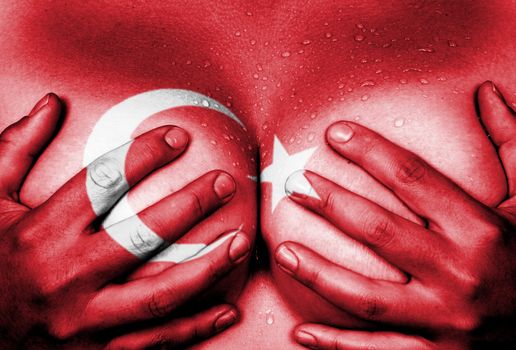 Sweaty upper part of female body, hands covering breasts, flag of Turkey