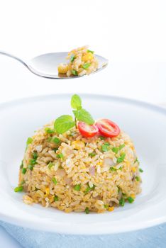 Chinese egg fried rice on dining table. Focus on the spoon.