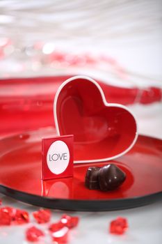 Red glass heart on a plate. Photo Frame inside heart