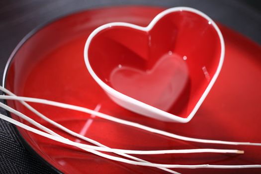 Red glass heart on a plate.