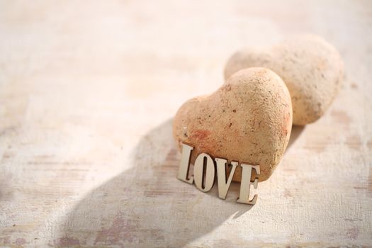 Heart of stone on the woody background with love inscription