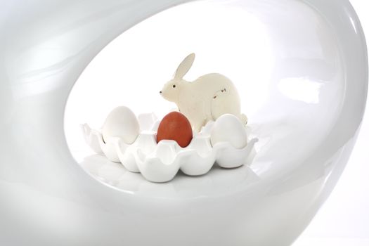Red easter egg and rabbit on the white plate