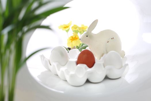 Red easter egg and rabbit on the white plate