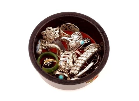 Various women's jewelry in the round box on a white background