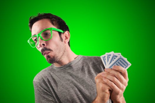 guy spying poker cards on green background