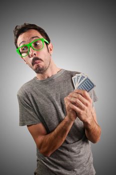 guy spying poker cards on grey background