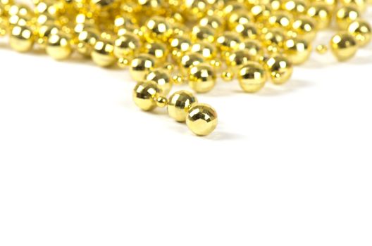 Background made of a brilliant celebratory beads of golden color over white