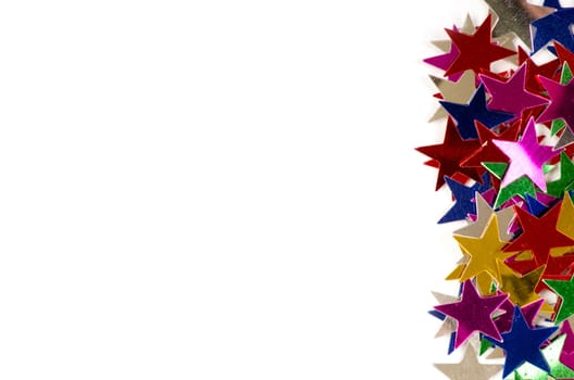 Christmas decoration of colored confetti stars against white background