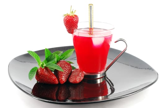 Ice tea with strawberries on black dish