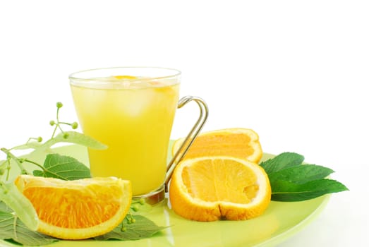Cold orange juice glass on green dish