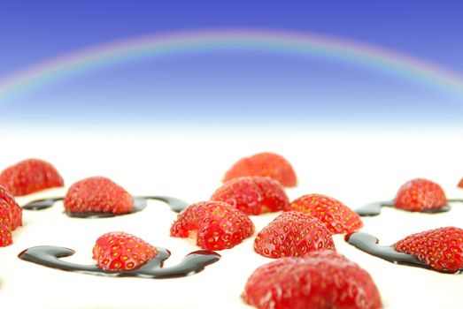 Sky with rainbow over red fresh strawberries
