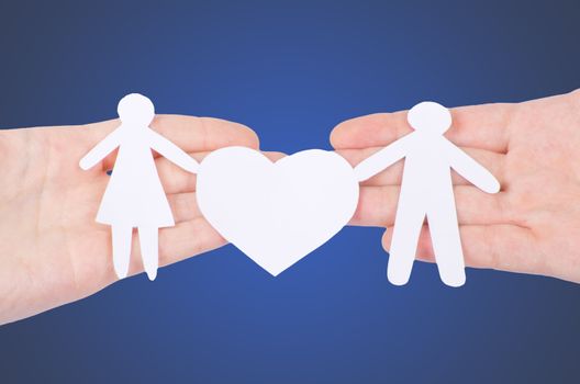 Paper family in hand with a big hearth isolated on white