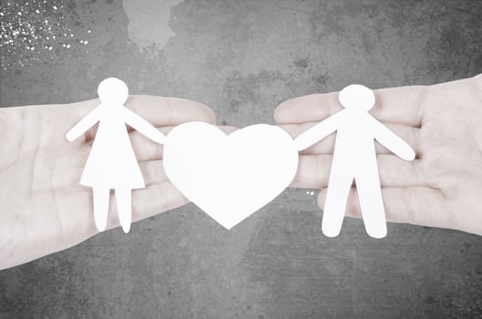 Paper family in hand with a big hearth isolated on white