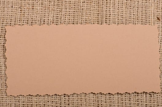 Old paper tag on natural burlap