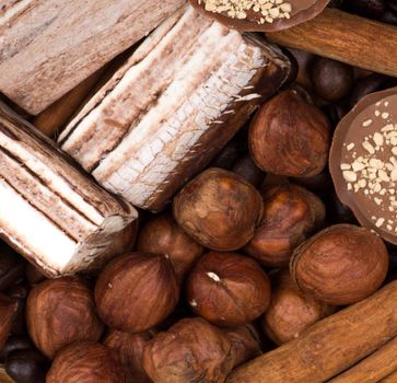 Sweets, cinnamon, nuts and coffee beans on a saucer, on burlap background.