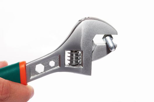 Hand holding a steel pipe wrench with bolt