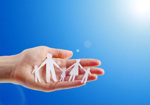 Paper family in hands isolated on blue sky