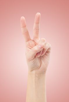 Hand with two fingers up in the peace or victory symbol. Also the sign for the letter V in sign language. Isolated on white.
