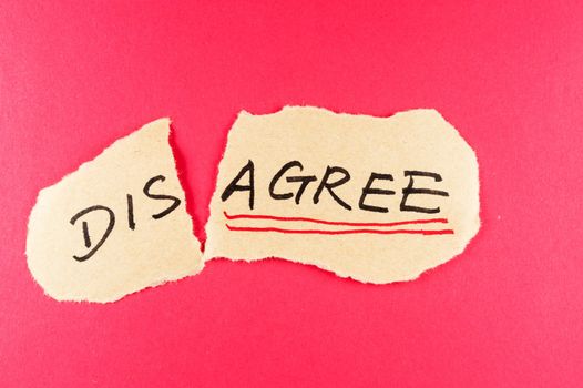 Disagree to agree concept words written on the paper against red background
