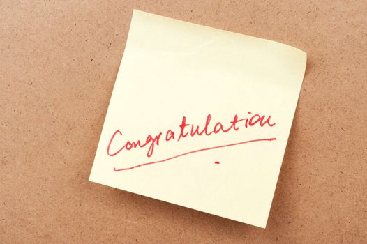 Congratulation word written on sticky note