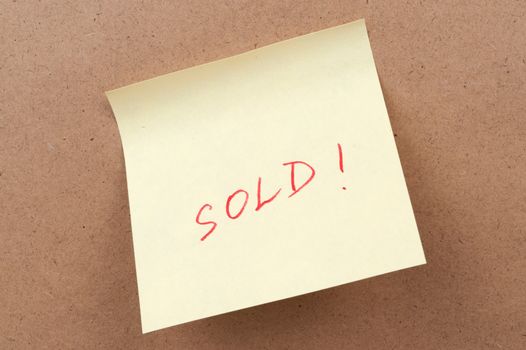 Sold word written on a sticky note