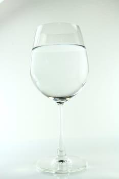 A full  wine glass of water on a neutral background