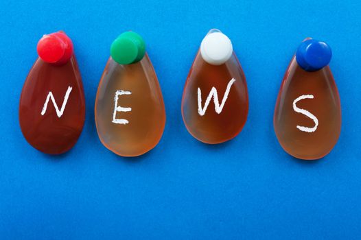 News word spelled with agates pinned on the board