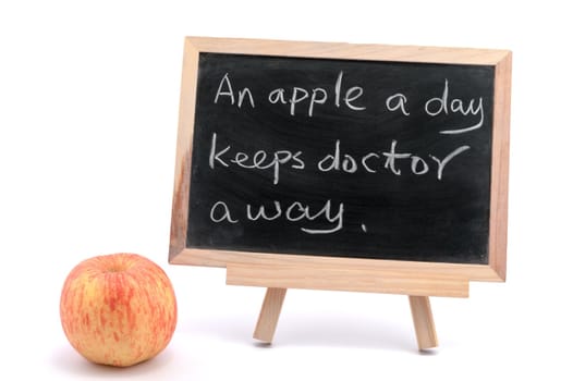 An apple a day keeps doctor away sayings written on blackboard