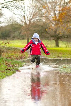 boy running in a large puddle