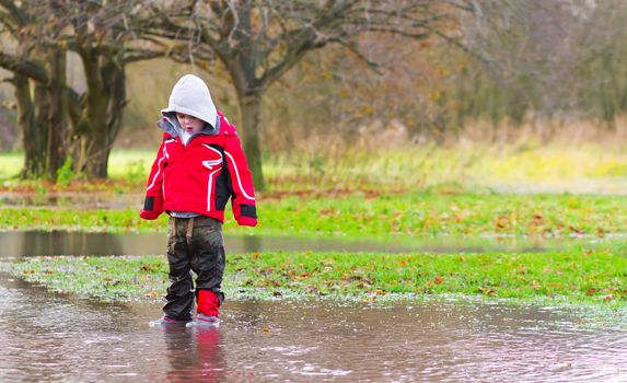 boy running in a large puddle