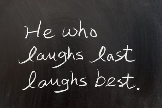 He who laughs last laughs best saying written on chalkboard