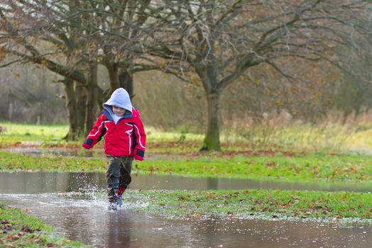 boy running in a large puddle