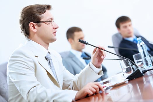 Image of three businesspeople at table at conference