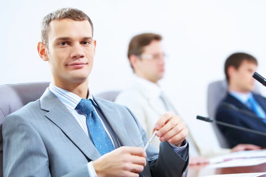 Image of three businesspeople at table at conference