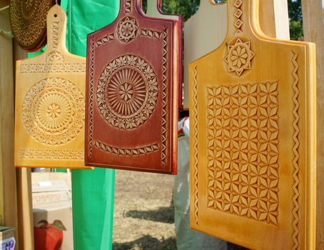 Three carved wooden kitchen boards an outdoor close-up.