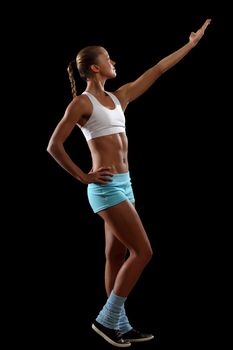 Fitness woman smiling standing against black background